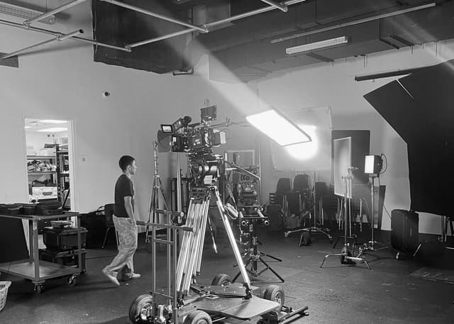 Camera operator beside a cinema camera on a studio dolly