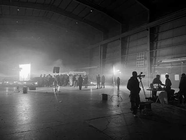 Film crew lighting a night shoot inside a warehouse
